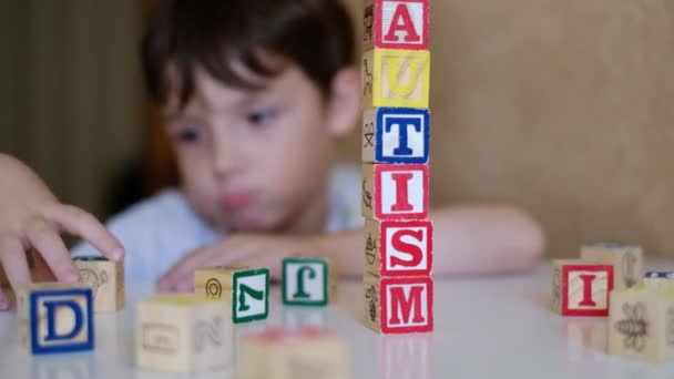 Wooden blocks spelling “AUTISM” on white surface—symbolic image highlighting autism awareness and early childhood education.